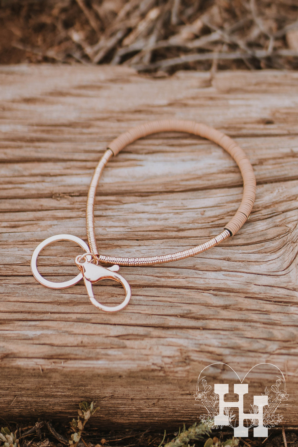 Two bracelt style keychains. Made from thin fake gold plated disk beads. One braclet keychain has thin gray disk beads and the other has light brown flat disk beads.