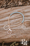 Thin Gold bracelet key chain. Half the braclet has flat thin gold beads and the other half is thin flat gray beads.