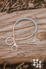 Thin Gold bracelet key chain. Half the braclet has flat thin gold beads and the other half is thin flat gray beads.