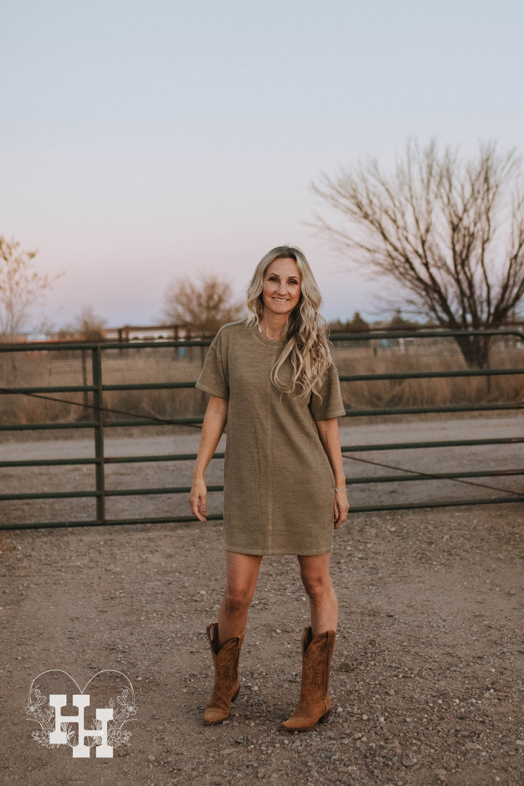 Girl wearing a knit light olive green tshirt dress with cowboy boots.