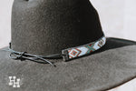 Hat band on black wide brim hat. Band is White, Black, Turquoise, brown and gold with black leather strap to tye on to hat.