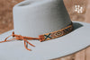Seed bead hat band on a mint green hat. Pictures shows how to tye hand band on to hat. The band is yellow, dark green, tan and white with brown leather straps on the ends.